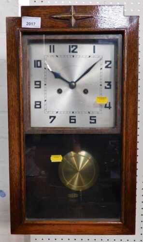 An Art Deco oak cased wall clock, with silvered dial, 48cm high.