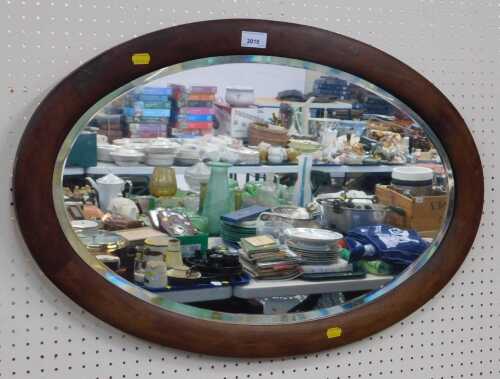A hardwood oval wall mirror, 50cm x 75cm.