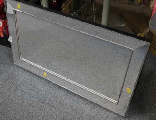 A rectangular mirrored finish wall mirror.