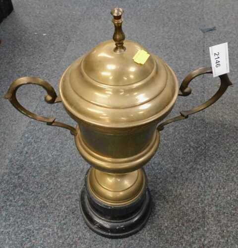 A brass two handled trophy cup, on plinth.