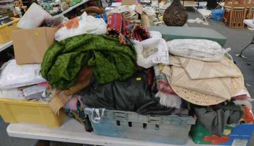 A group of assorted clothing, material offcuts, throws, linen, tablecloths, footlets, etc. (4...