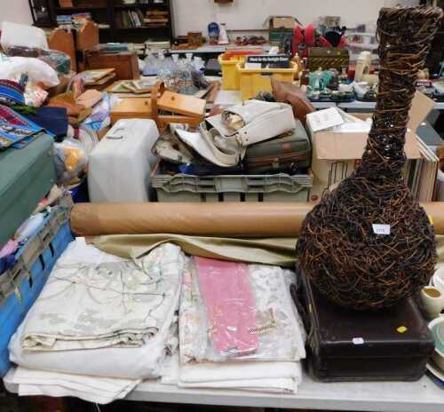 Upholstery and curtain material, a wicker vase, and a brown leather suitcase.