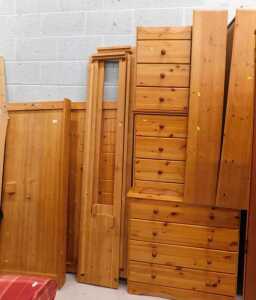 A pine part bedroom suite, comprising two three drawer bedside cabinets, a four drawer chest,...