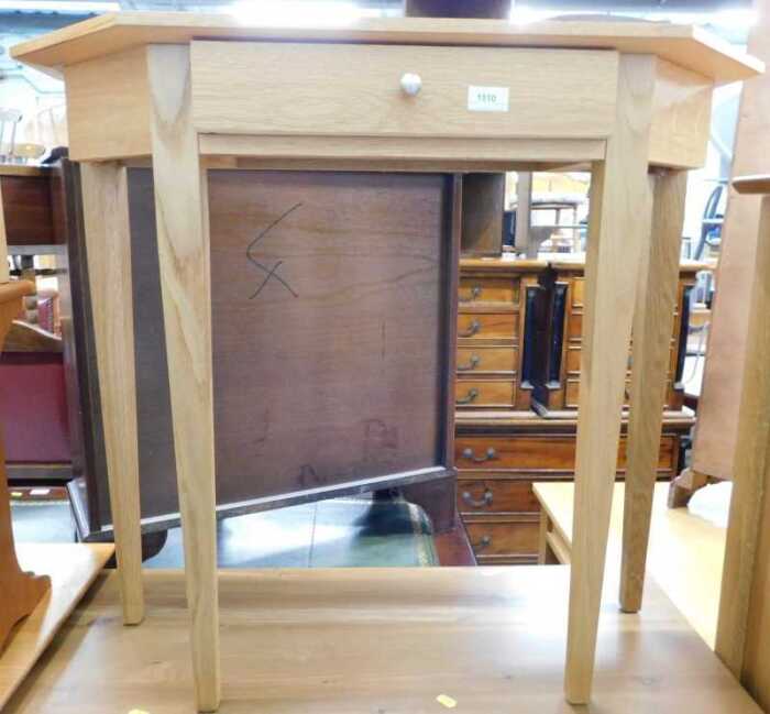 V - A light oak hall table, with canted top on square tapering legs. Note: VAT is payable on the...