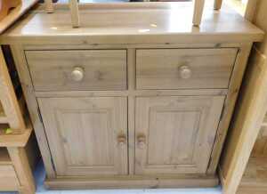 V - A pine side cabinet, with two drawers, raised above double cupboard. Note: VAT is payable on the...