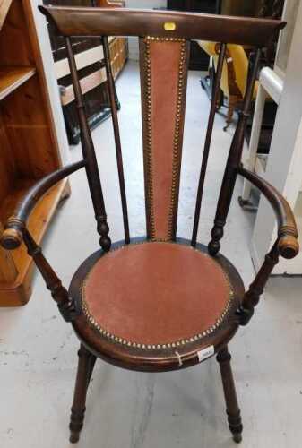 An occasional armchair, with overstuffed back and circular seat, on turned legs joined by a H...
