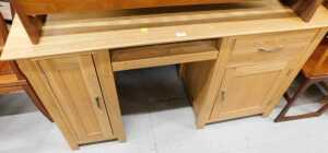 V - A light oak computer desk, with cupboards, drawer and pull out section. Note: VAT is payable on...