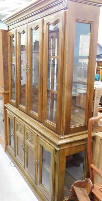 A four door glazed bookcase, with fixed cornice, raised above adjustable shelves and four...