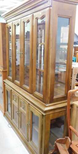 A four door glazed bookcase, with fixed cornice, raised above adjustable shelves and four...