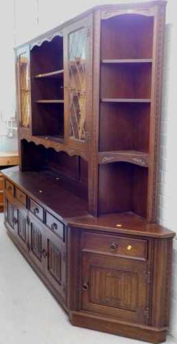 An Old Charm style oak finish display cabinet, with open shelves flanked by lead glass panel...