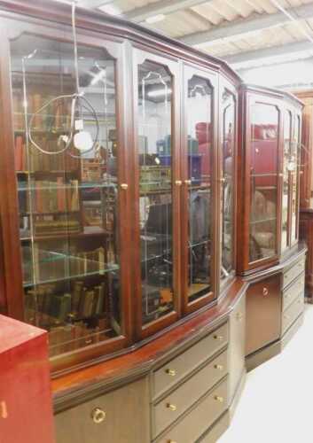 A Stag display cabinet, with central glazed doors flanked by further doors, above three long...