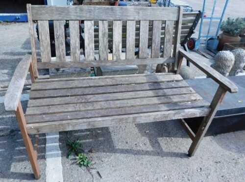 A slatted two seater wooden garden bench.
