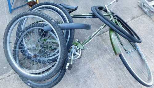 A Triumph bicycle, with chrome mounts and leather seat, and various bike wheels.