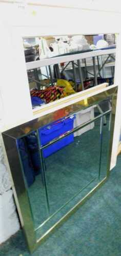 An oval framed mirror, and a further square mirror with shaped sections to the outline.