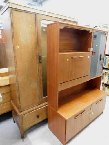 V - A 1970s teak display cabinet, with glazed door aside fall, above double cupboards, on stiles,...