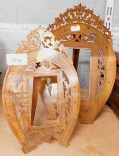 Two highly elaborate carved wooden frames, with pierced scroll finials and fretwork horseshoe...