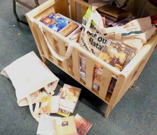 A wooden mid century cream painted child's cot, containing DVDs and CDs, to include Disney Pixar...