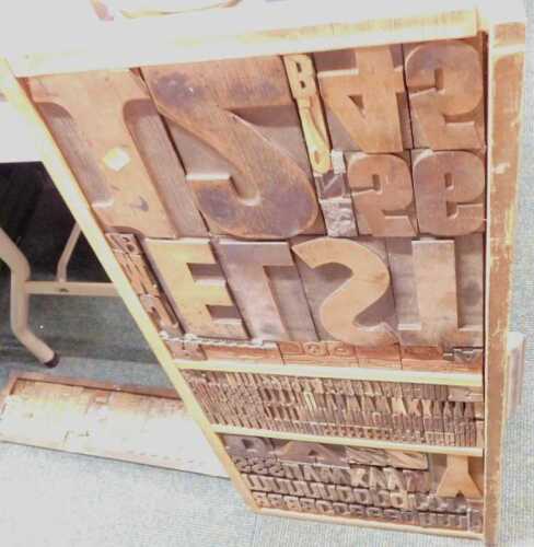 Two decorative wall hangings, made from wood and copper printing blocks.