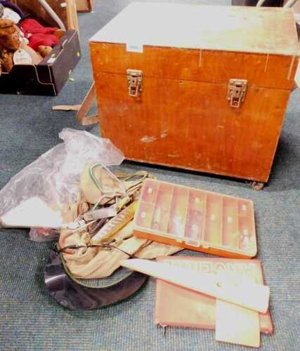 A wooden fishing tackle box, containing various equipment, including lures, hooks, rod stands,...