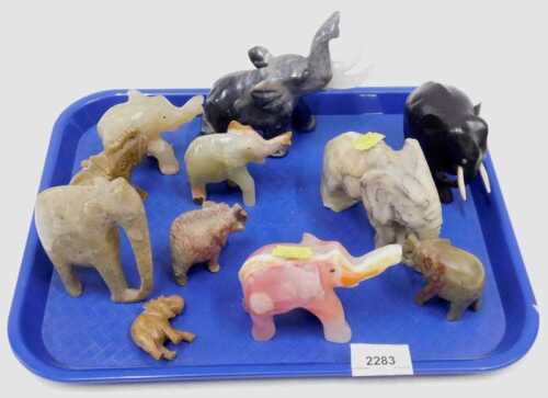 A collection of carved wooden and soapstone elephants, varying sizes and colours.