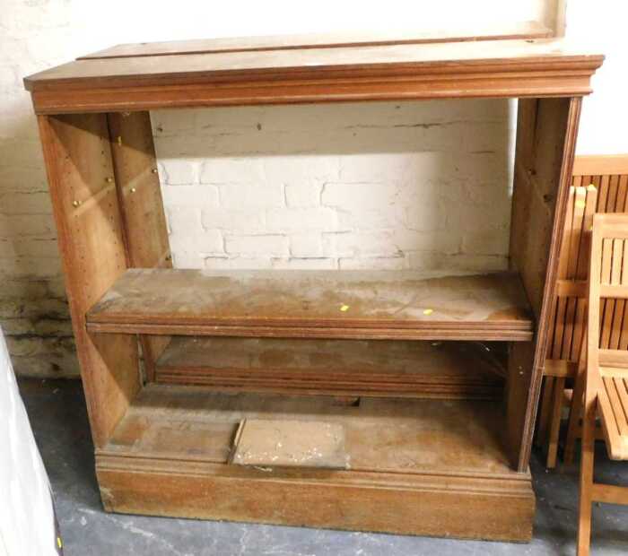 Two similar oak open bookcases, each with a moulded top above various shelves, on a moulded...