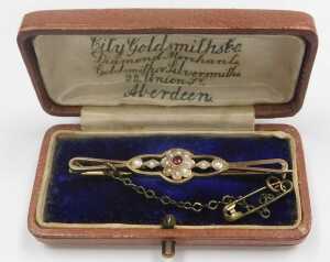An Edwardian garnet and seed pearl floral bar brooch, in yellow metal, stamped 9c, with a later... - 2