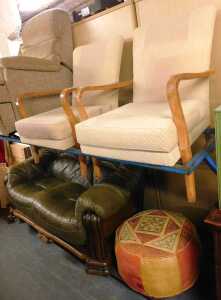 Two oak framed open armchairs, together with a leather upholstered pouffe, and a two seater...