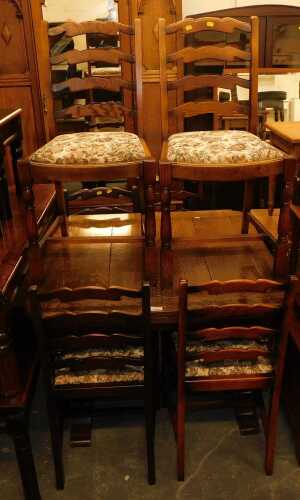 An oak draw leaf table, together with six ladderback chairs, each with an overstuffed tapestry...