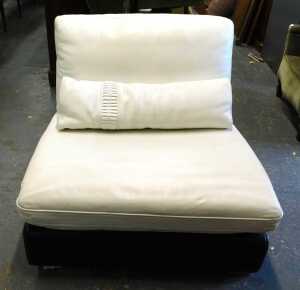 A two tone faux leather chair, raised on chrome feet, 90cm wide. 
The upholstery in this lot...
