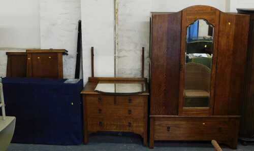 An early 20thC oak bedroom suite, comprising wardrobe, mirror back dressing table, and bed frame,...