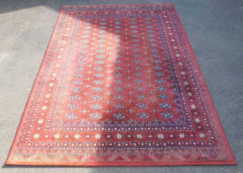 A red ground machine woven rug, 192cm wide.