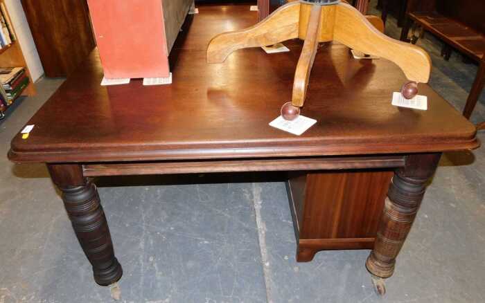 A late Victorian stained oak extending dining table, raised on cylindrical turned legs, on...