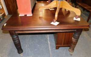 A late Victorian stained oak extending dining table, raised on cylindrical turned legs, on...