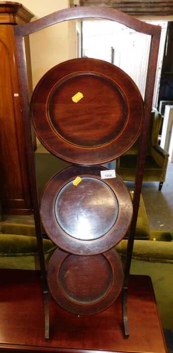A mahogany and boxwood line inlaid three tier folding cake stand, 83cm high. (AF)