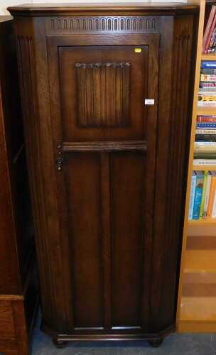 An oak Old Charm style hallrobe, the carved and panelled door enclosing a shelf, hanging rail,...