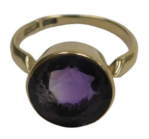 An amethyst solitaire ring, the brilliant cut stone in a high closed setting, in yellow metal,...