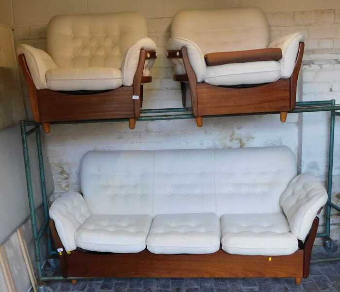 A mid century teak framed three seater sofa, with cream button back and loose cushion seats,...