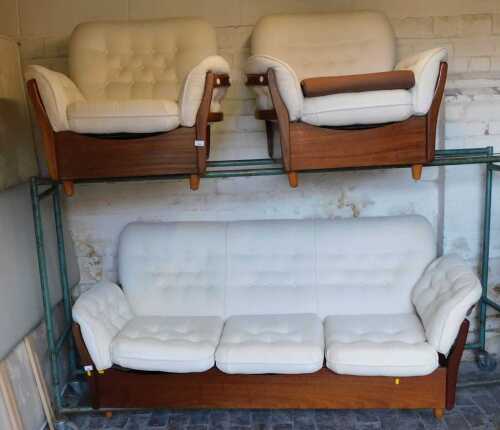 A mid century teak framed three seater sofa, with cream button back and loose cushion seats,...