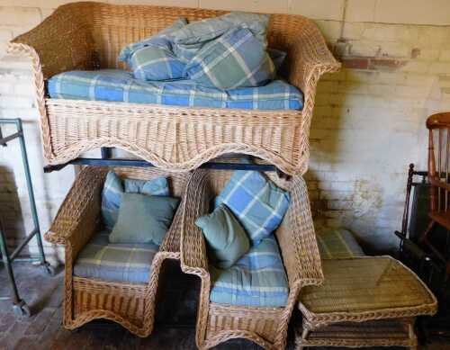 A wicker conservatory suite, comprising two seater sofa, two armchairs, and a table. The...