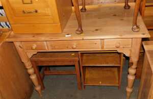 A pine side table, with an arrangement of three drawers, raised on cylindrical turned legs, 76cm...