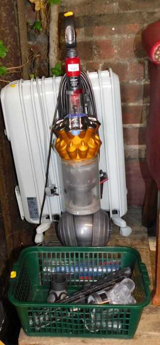 A Dyson upright vacuum cleaner, together with a De'Longhi electric oil filled radiator.