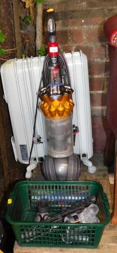 A Dyson upright vacuum cleaner, together with a De'Longhi electric oil filled radiator.