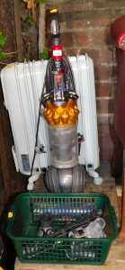 A Dyson upright vacuum cleaner, together with a De'Longhi electric oil filled radiator.