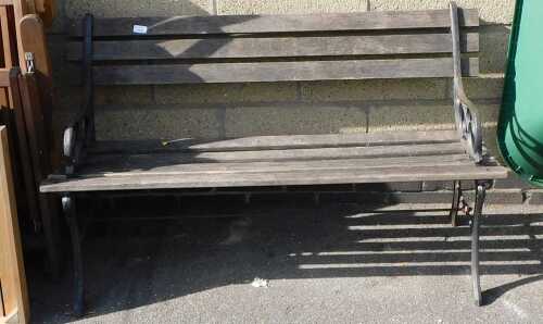 A garden bench, with cast metal end supports, and wooden slatted base.