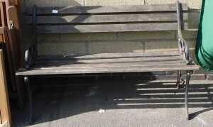 A garden bench, with cast metal end supports, and wooden slatted base.