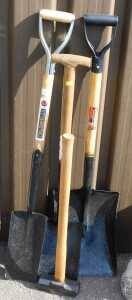 Three shovels, together with a sledge hammer.