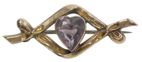 An Edwardian 9ct gold and amethyst sweetheart brooch, the heart shaped amethyst in a closed...