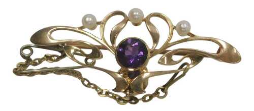 An Edwardian Art Nouveau amethyst and seed pearl set brooch, in a sinuous foliate design, with...