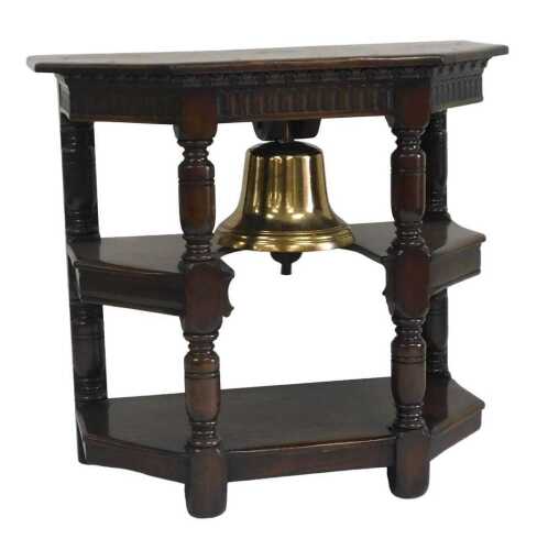 A metal ship's bell, mounted into an oak three tier side cabinet, with fluted frieze and turned...