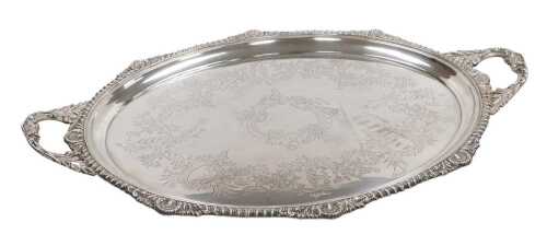 An Edward VII silver oval twin handled tray, with engraved Rococo style decoration of flowers...